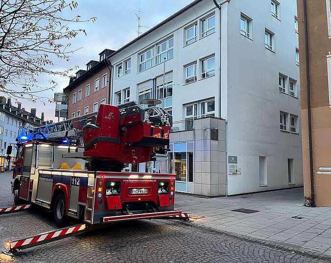 Feuerwehrfahrzeug mit Drehleiter vor einem Gebäude