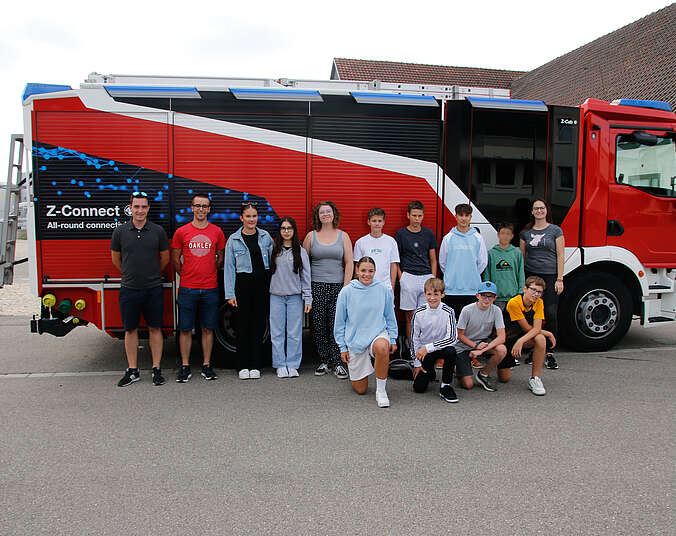 Gruppenbild vor einem Löschfahrzeug der Firma Ziegler