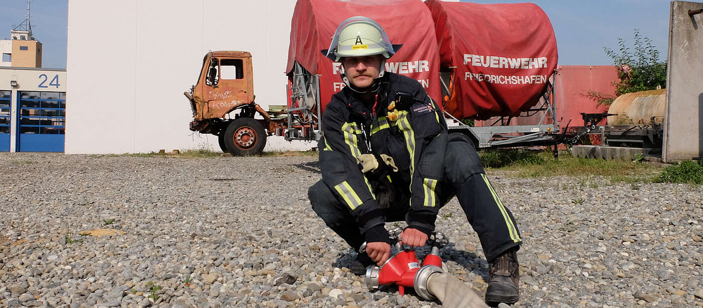 Feuerwehrmann mit Wasserschlauch