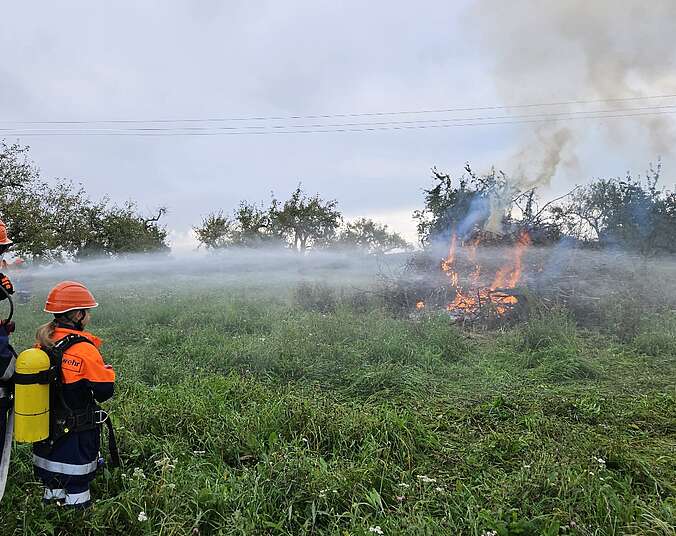 Zwei Jugendfeuerwehrler löschen ein Feuer