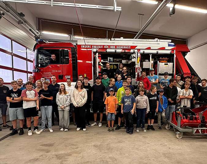 Die Teilnehmer vor einem Feuerwehrauto der Feuerwehr Riezlern